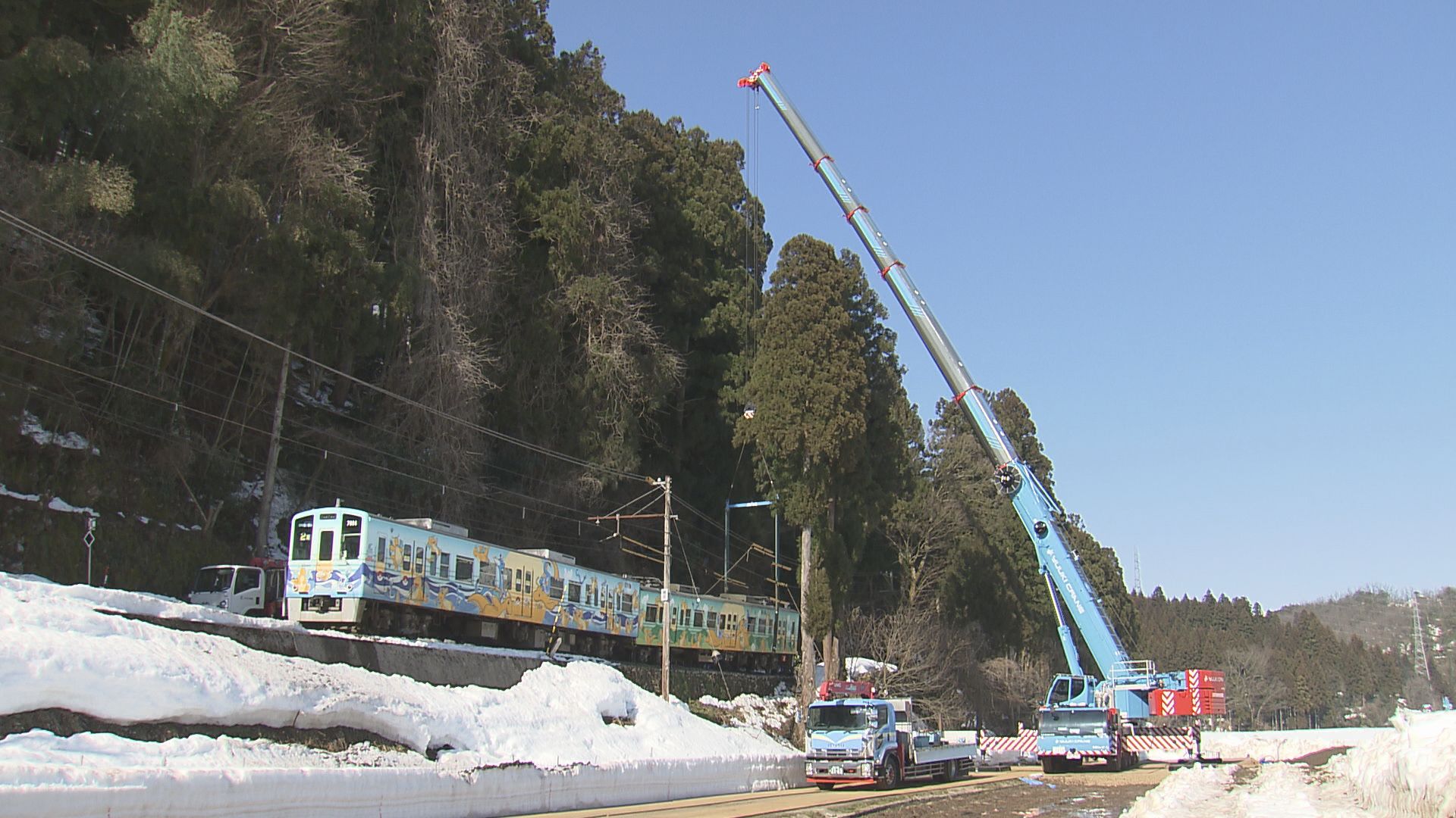 脱線車両をクレーンで吊り上げ線路に戻す作業