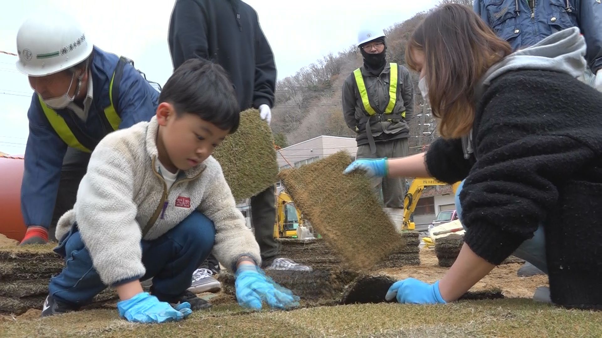 公園に芝を貼る親子