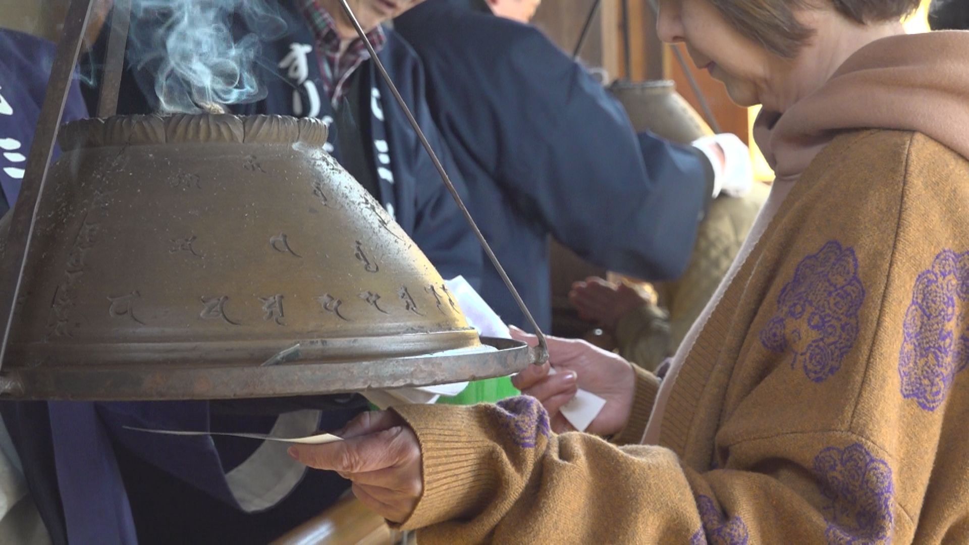 写真を手に祈る人も