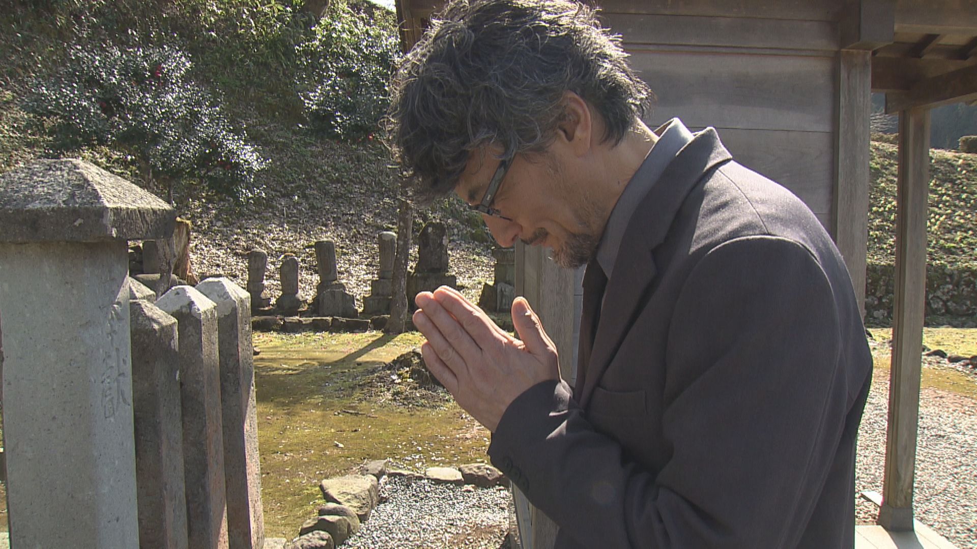 義景の墓に手を合わせる山口さん